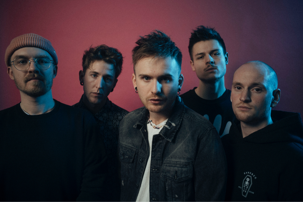 The five musicians of Wait of the World stand close together as a group. Their gazes are directed directly at the camera.